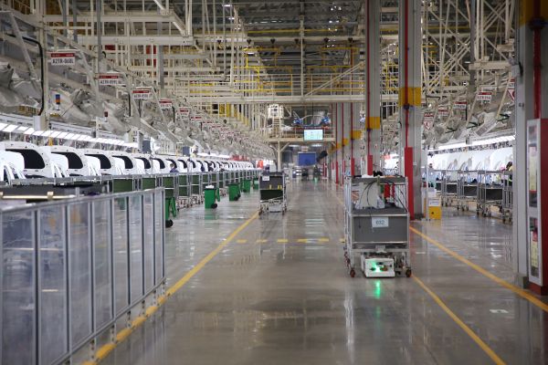 自動(dòng)化牽引小車穿行在北汽株洲基地二工廠的總裝車間里。