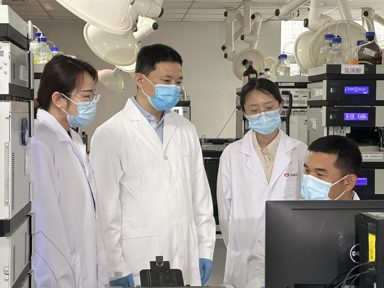 賈振華（左二）與科研人員在討論業(yè)務(wù)。 孫陽陽攝