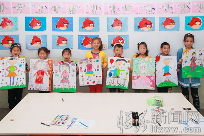 5月10日，洪洞縣的幾名小學生在展示他們的畫作。王培基 攝